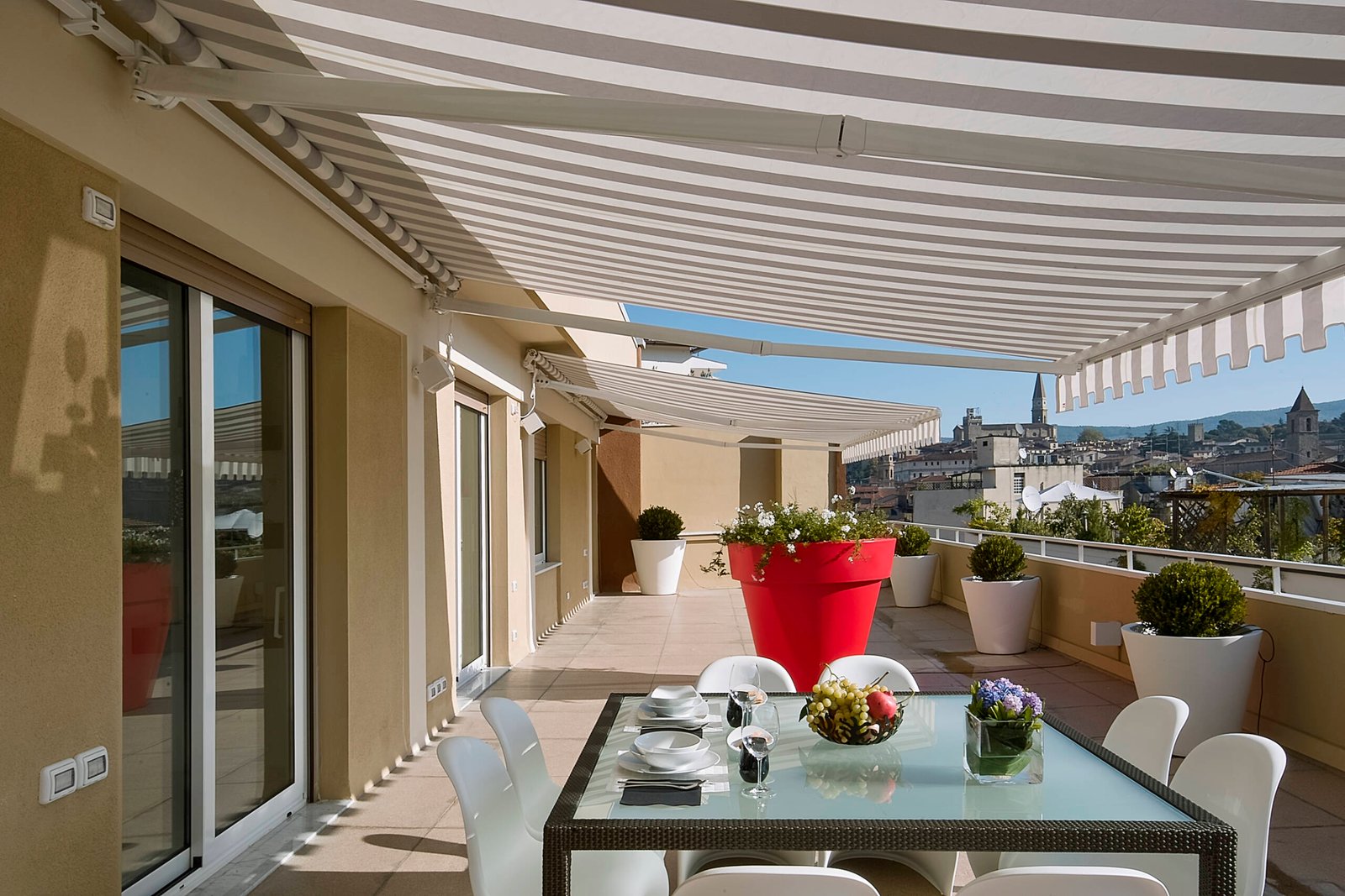 exteriors shots with the foreground glass dining table with plates and a bunch of grapes